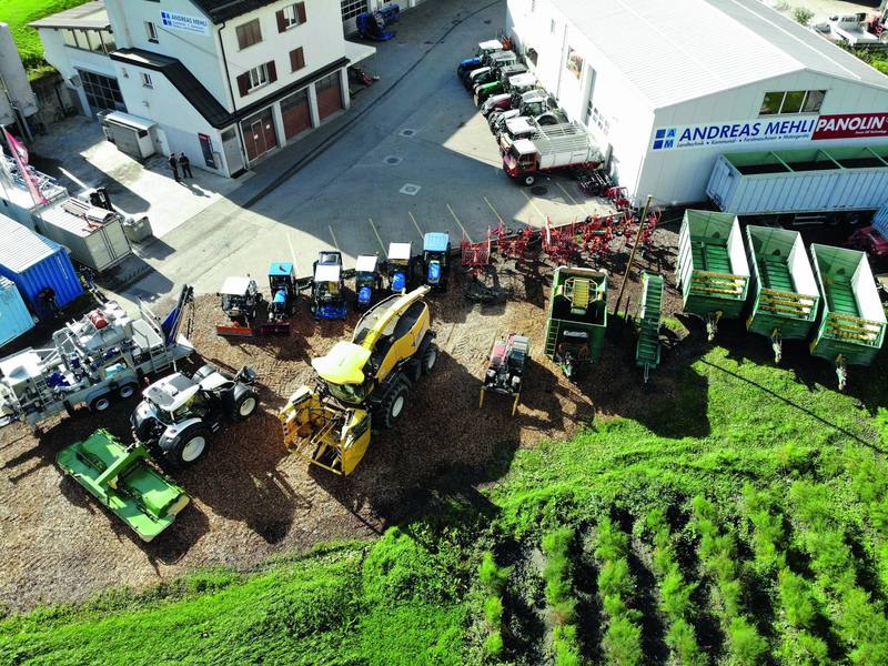 Luftaufnahme des Betriebsareals an der Rheinmühle mit Traktoren, Häckslern, Ladewagen und Anbaugeräten, die zum Verkauf bereitstehen